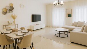 Ein modernes Wohnzimmer mit Essbereich, einer Couch, einem Fernseher und einer Pendelleuchte.