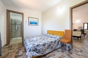 Ein Schlafzimmer mit Bett, Stuhl, Dusche und Essbereich.