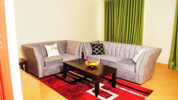 Deluxe-lejlighed - byudsigt | Opholdsområde | 32-tommers smart-tv med digitale kanaler