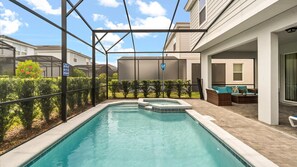 A swimming pool with a hot tub, surrounded by a covered patio area with seating and a view of neighboring houses. - Luxe 7BR Solterra Villa Games Pool Themed Rooms (Davenport)