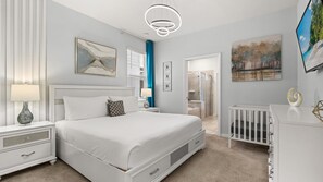 A modern bedroom with a large bed, bedside tables, a dresser, and a walk-in closet. - Luxe 7BR Solterra Villa Games Pool Themed Rooms (Davenport)