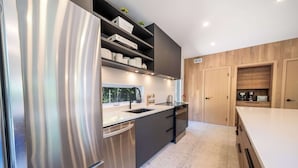 Een moderne keuken met roestvrijstalen apparatuur, houten kastjes en een groot aanrecht.