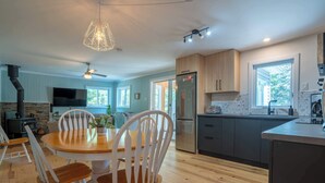 Een moderne keuken met een centraal eiland, houten stoelen en een inbouwfornuis.