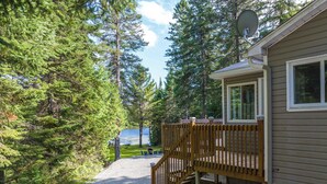 Een chalet met een grindpad dat leidt naar een houten terras en trap.