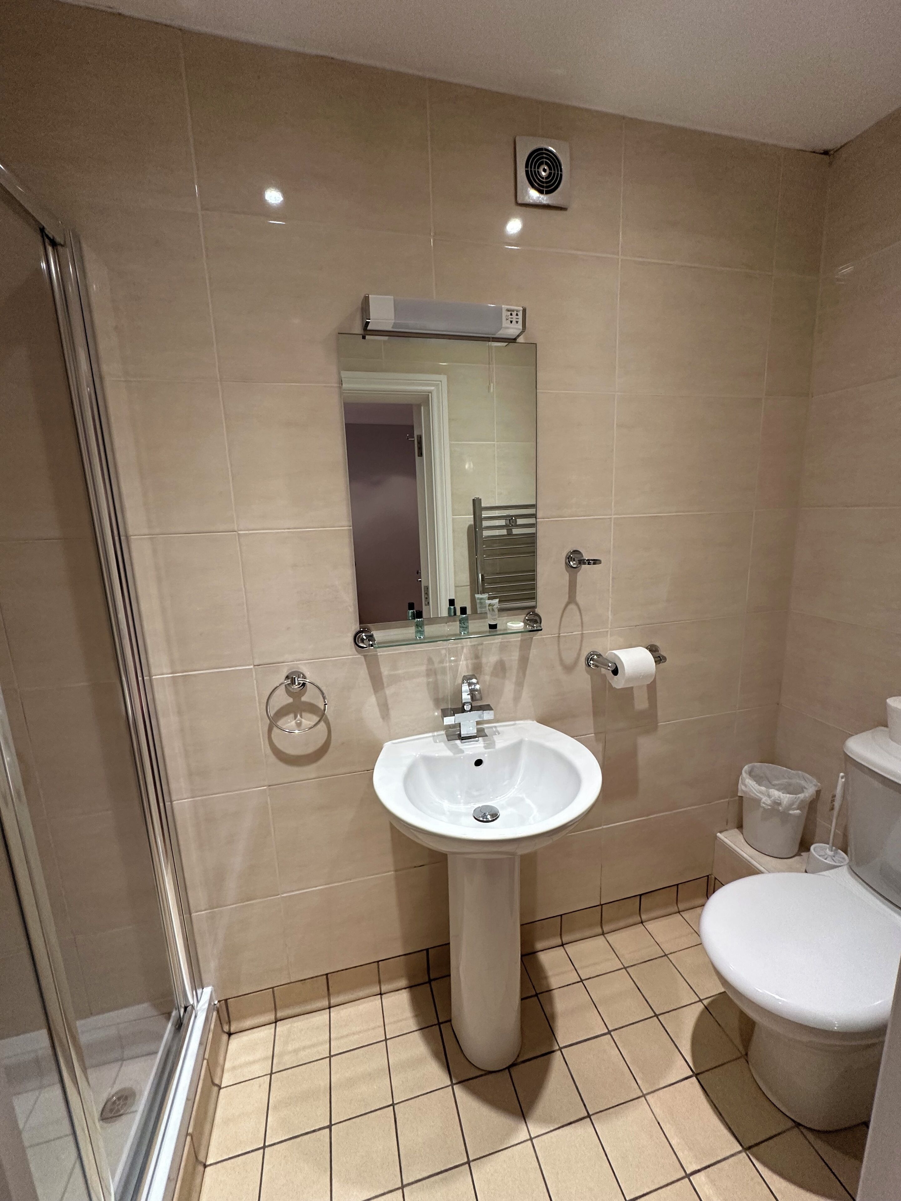 A bathroom with a sink, toilet, and shower.