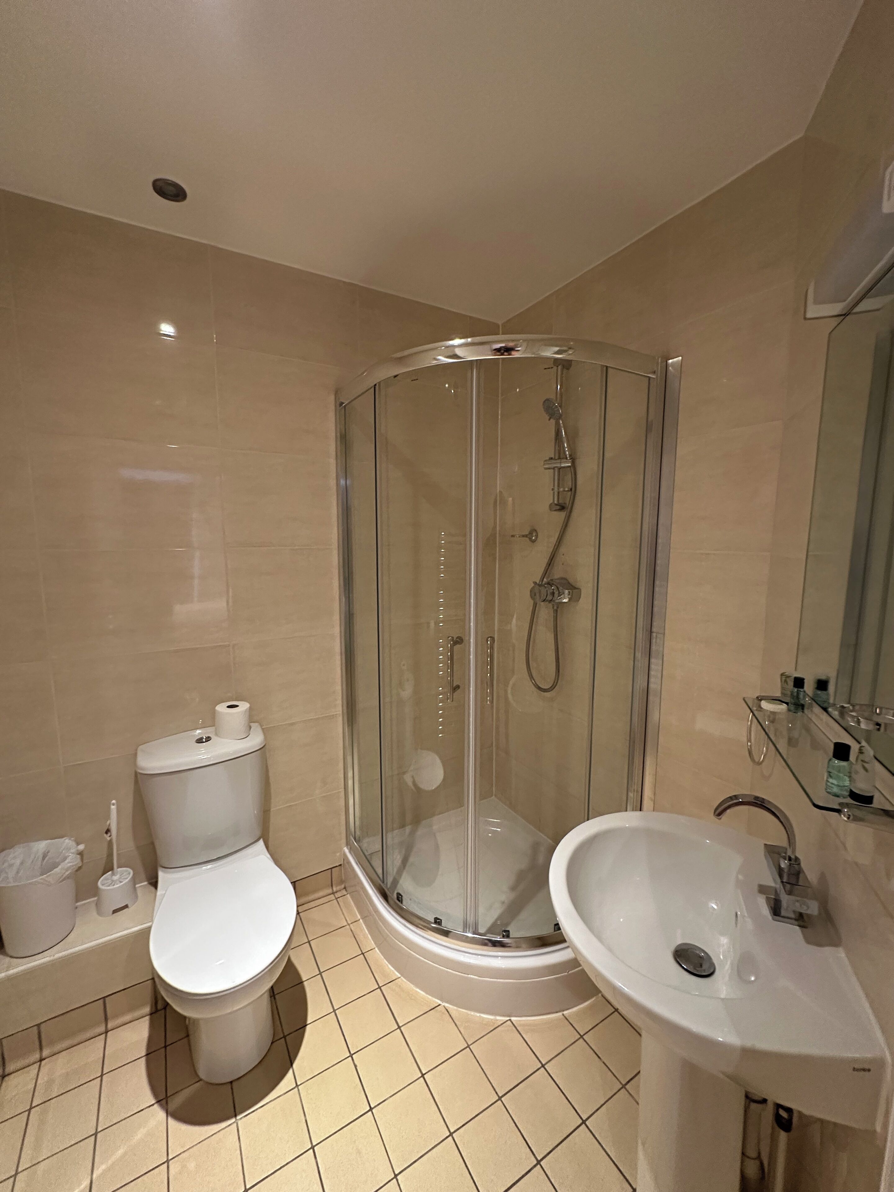 Une salle de bain moderne avec une douche à parois de verre, des toilettes et un lavabo.