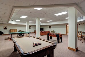 Un'ampia area ricreativa interna con tavolo da biliardo, tavolo da calcio e tavolo da snooker.