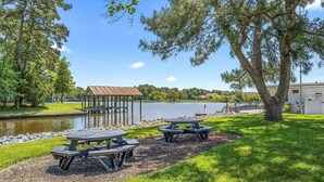 Un espace de pique-nique au bord du lac, équipé de tables de pique-nique et d’un kiosque.