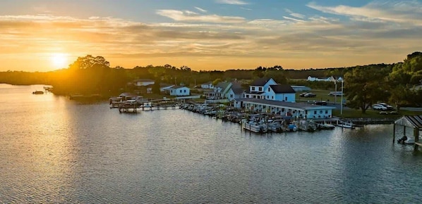 A waterfront property with a dock, a large house, and several smaller buildings.