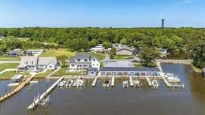 A lakeside property with a dock, several boats, and houses.