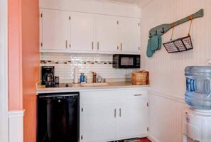 A compact kitchen with white cabinets, a microwave, a coffee maker, and a water dispenser. - Inn on Turville Cottage, Sleeps 4, Waterfront (Berlin)