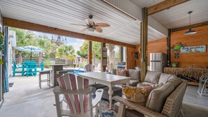 Eine Terrasse im Freien mit Esstisch, Stühlen und einer Couch.