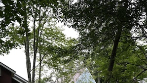 Un chemin de gravier mène à un bâtiment à la façade bleue, avec un bâtiment rouge situé sur la gauche.