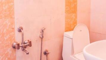 Une salle de bain équipée de toilettes, d’un bidet et d’un lavabo.