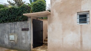 A building entrance with a black door, a small window, and a sign reading 'HOMERO 6'.
