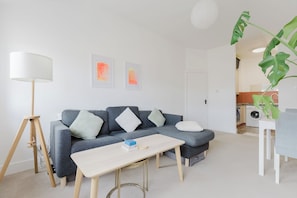 Un salon moderne avec un canapé gris, une table basse en bois et un lampadaire.