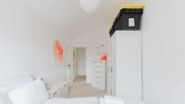 Une chambre d’hôtel comprenant un lit, un bureau, une armoire et un meuble de rangement.
