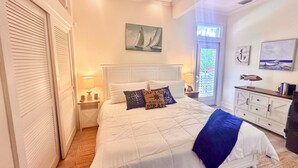 Une chambre à coucher comprenant un lit, des tables de chevet, une commode et des œuvres d’art accrochées aux murs.