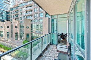 A modern building with a glass facade, a balcony with a metal railing, and a view of the surrounding area. - Atlantis at Waterpark City Condos in DT (Toronto)