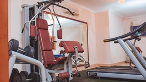 A gym with exercise equipment, a treadmill, and a mirror. - Mar... Guesthouse (Lobito)