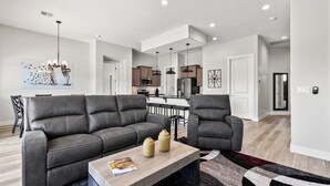 Un salon moderne avec un canapé gris, une table basse en bois et un tapis à motifs.