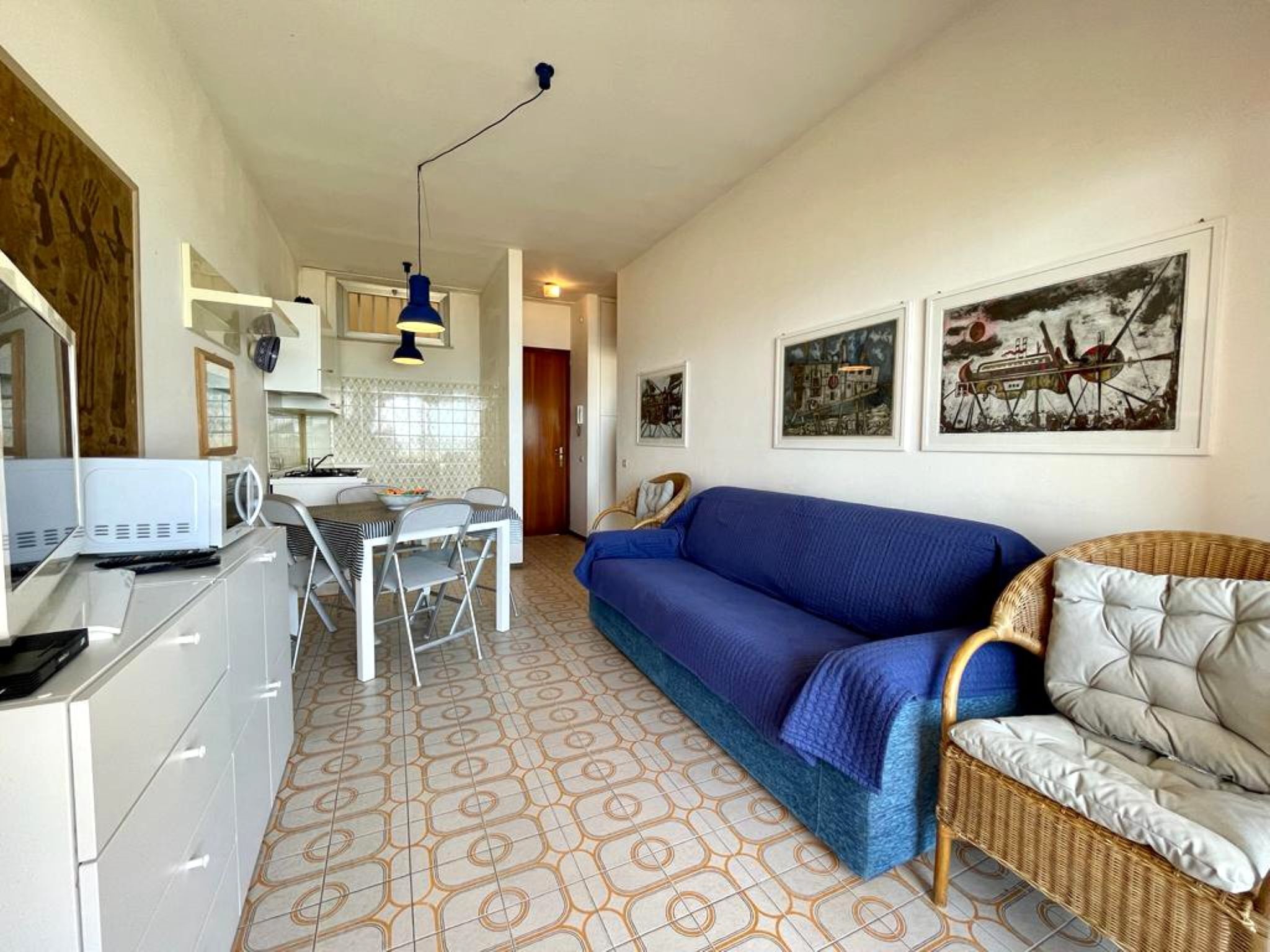 A compact living space with a kitchenette, a dining area, and a sofa.