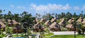 A resort with multiple bungalow-style buildings, a swimming pool, and palm trees. - Eco Resort - Praia dos Carneiros (Tamandaré)