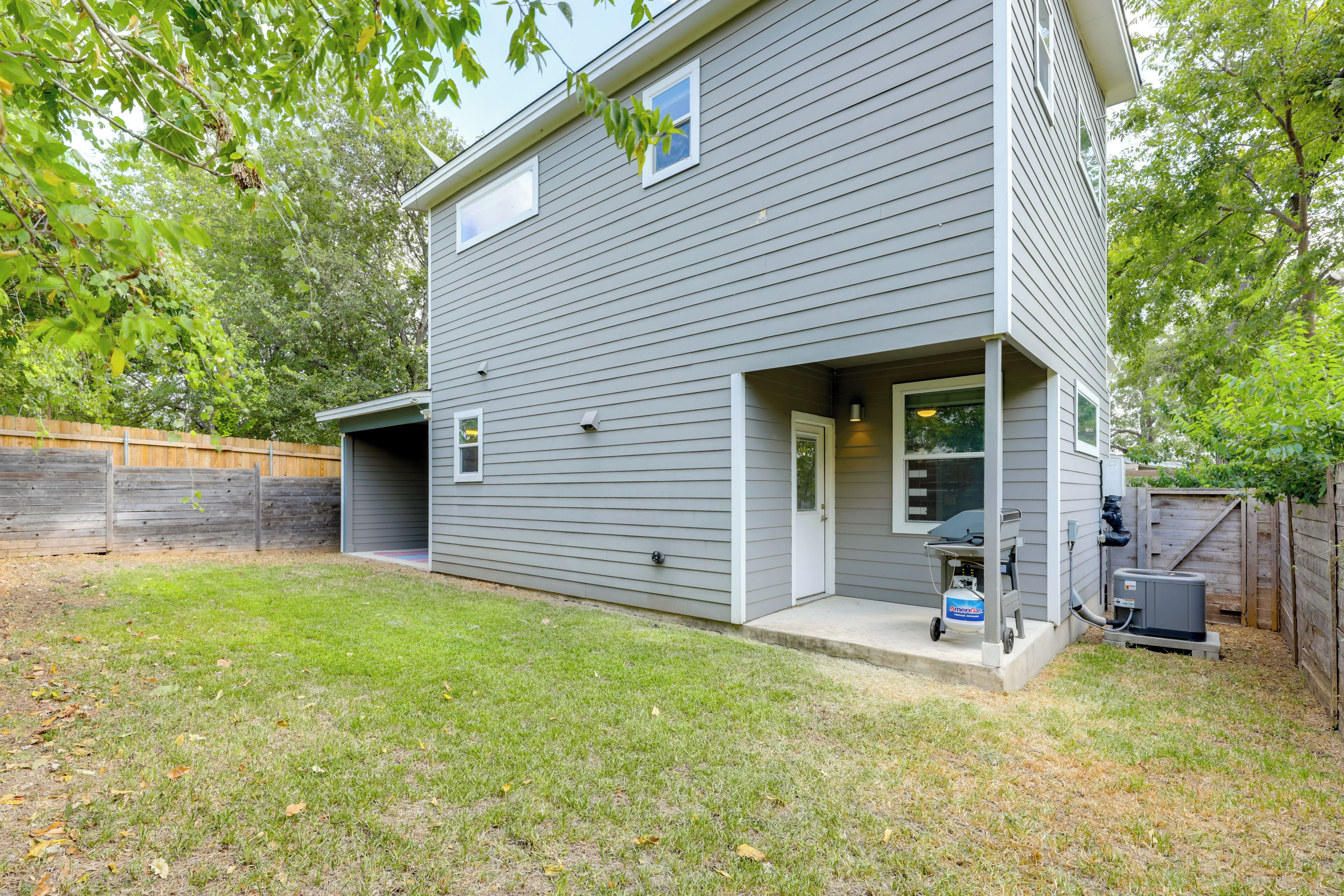 A two-story house with a garage, a covered porch, and a small attached shed.