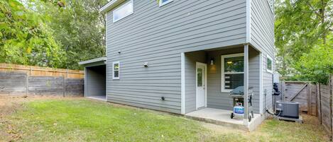 A two-story house with a garage, a covered porch, and a small attached shed.