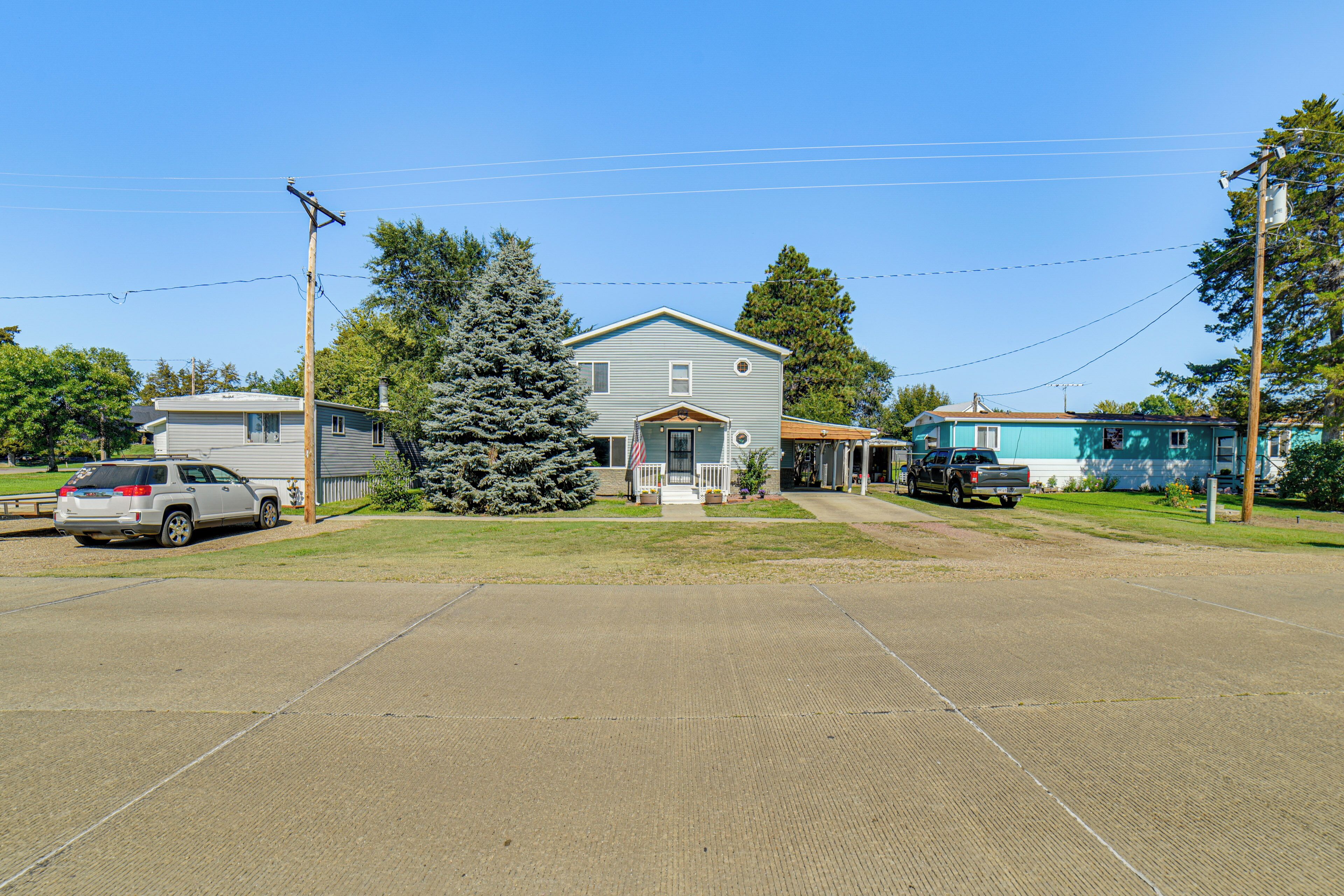 A residential area with houses, a driveway, and parked vehicles.