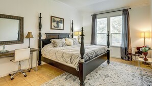 A bedroom with a four-poster bed, a desk with a chair, a large window with curtains, and a ceiling fan. - 5 Mi to Lake Travis: Pet-friendly Home w/ Yard! (Lakeway)