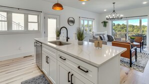 A spacious kitchen with a large island, white cabinetry, and pendant lighting. - Private Boat Slip, Scenic Views: Norris Lake Condo (La Follette)