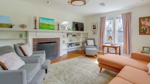 A living room with a fireplace, sofas, a television, and a chandelier. - Walk to Hudson River Waterfront: Newburgh Home (Newburgh)