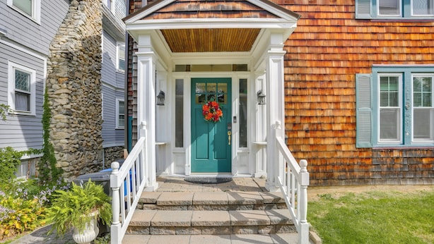 A house with a stone staircase leading to a green door, white railings, and a wooden porch. - Walk to Hudson River Waterfront: Newburgh Home (Newburgh)