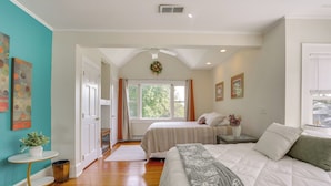 A bedroom with two beds, a ceiling fan, a window with curtains, and a small table with a plant. - Walk to Hudson River Waterfront: Newburgh Home (Newburgh)