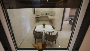 A modern kitchen with a dining area visible through a glass partition. - Pearl of Varanasi (Varanasi)