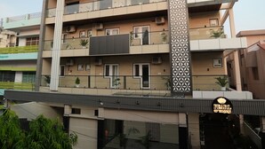 A multi-story hotel with a modern design, featuring balconies, air conditioning units, and a decorative column. - Pearl of Varanasi (Varanasi)