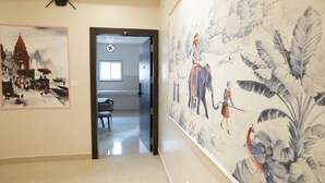 A hallway with a large mural, a door with a sign, and a glimpse of a dining area. - Pearl of Varanasi (Varanasi)