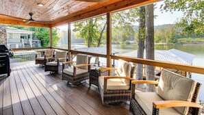 A covered outdoor deck with wicker furniture and a view of a lake. - < 1 Mi to Boat Launch: Home w/ Dock in Scottsboro (Scottsboro)