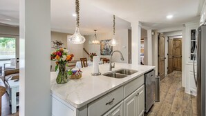 A modern kitchen with a marble countertop, stainless steel sink, and overhead pendant lights. - < 1 Mi to Boat Launch: Home w/ Dock in Scottsboro (Scottsboro)