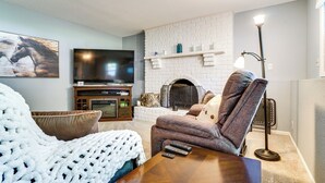 A living room with a fireplace, a television, and a cozy seating area. - 1 Mi to White Bear Lake & Dtwn: Twin Cities Escape (White Bear Lake)