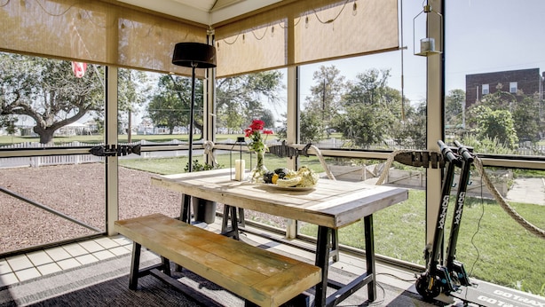 A covered outdoor seating area with a table, benches, and a bicycle rack. - Marinafront Cottage Sunrise, Fire Pit, Fireworks (Cambridge)