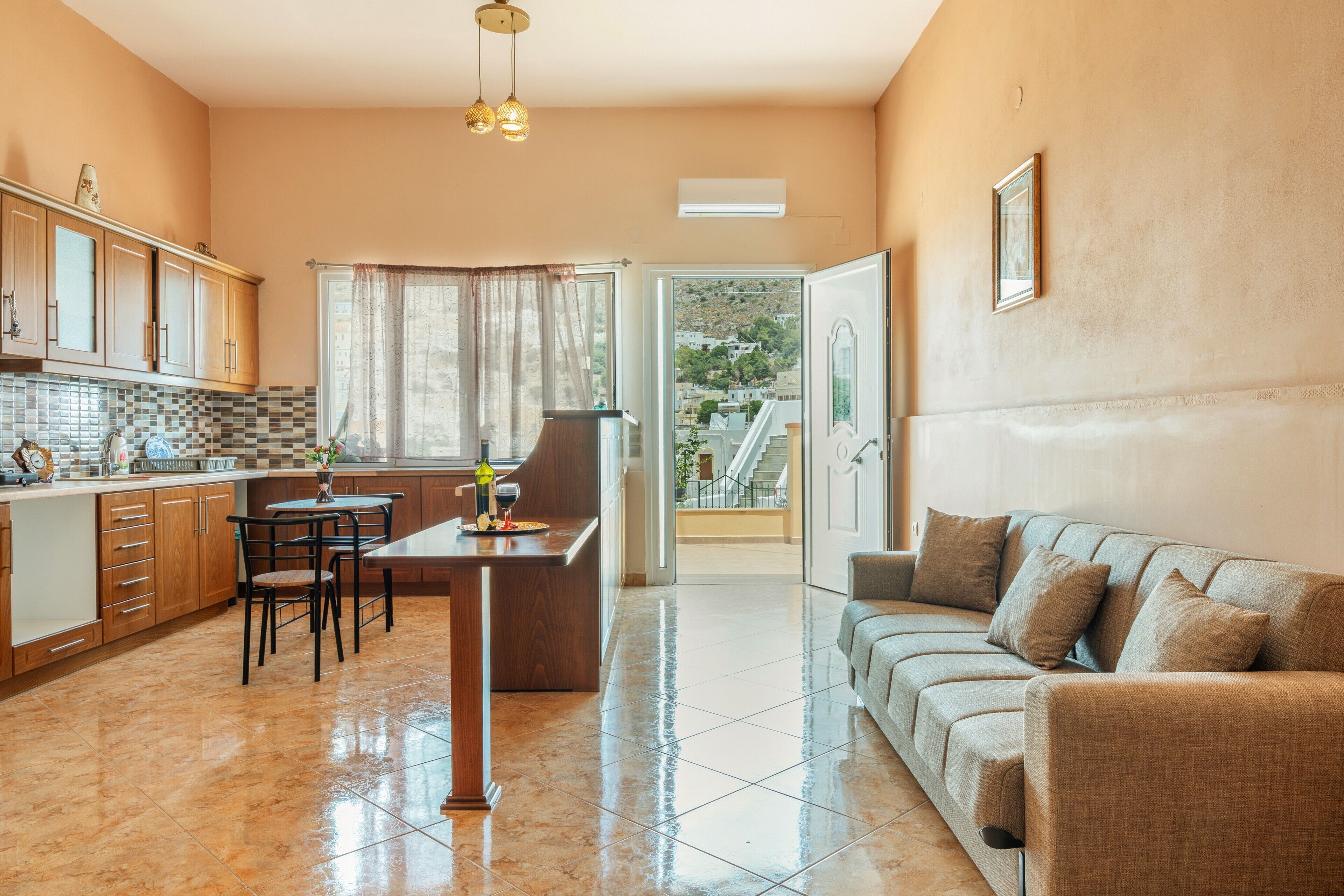 Cozinha moderna com área de refeições, um sofá e vista para o exterior.