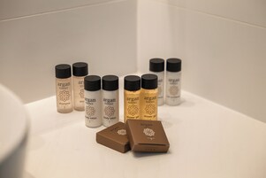 A bathroom shelf with various Argan products including shampoo, body lotion, and shower gel.