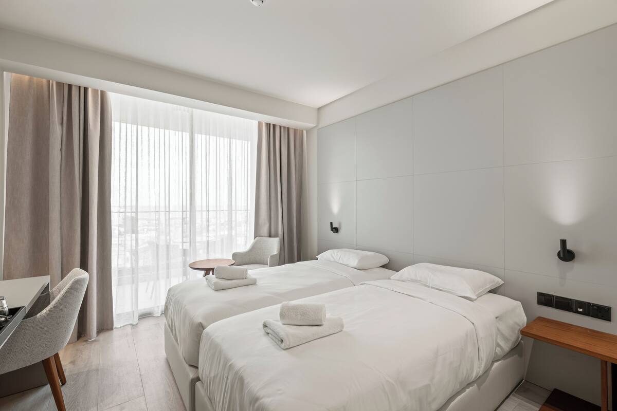 Una habitación de hotel moderna con dos camas, un escritorio y una silla.