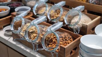 Un buffet proposant une variété de plats présentés dans des récipients en verre et sur des plateaux en bois.