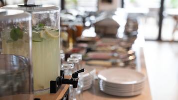 A beverage dispenser with a clear container filled with a drink, mint leaves, and lemon slices.