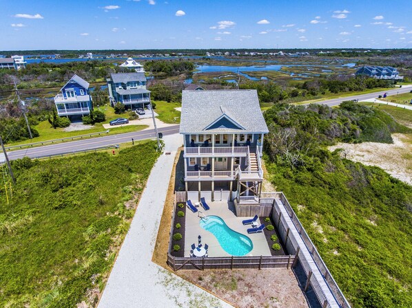 A large two-story house with a swimming pool and a deck area. - Good Tide-ings | Pet-friendly + Private Pool (North Topsail Beach)