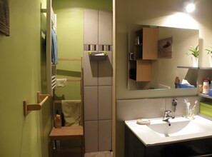A bathroom with a sink, mirror, towel rack, and a cabinet.