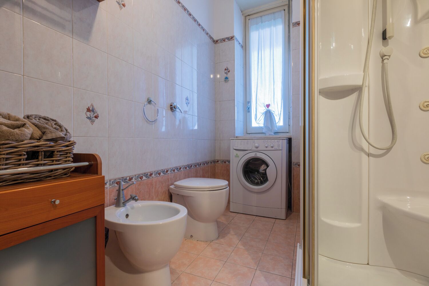 Un baño con inodoro, bidé, lavadora y bañera.